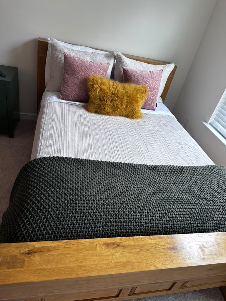Neatly made bed after cleaning service