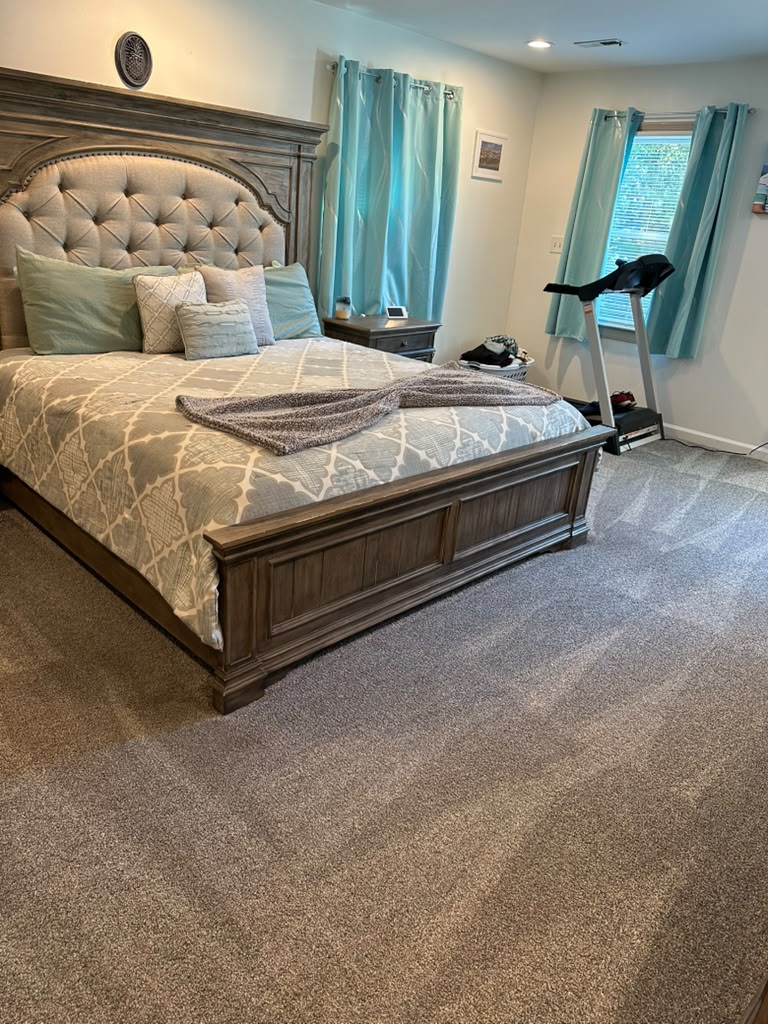Spacious primary bedroom with plush carpet after a deep cleaning