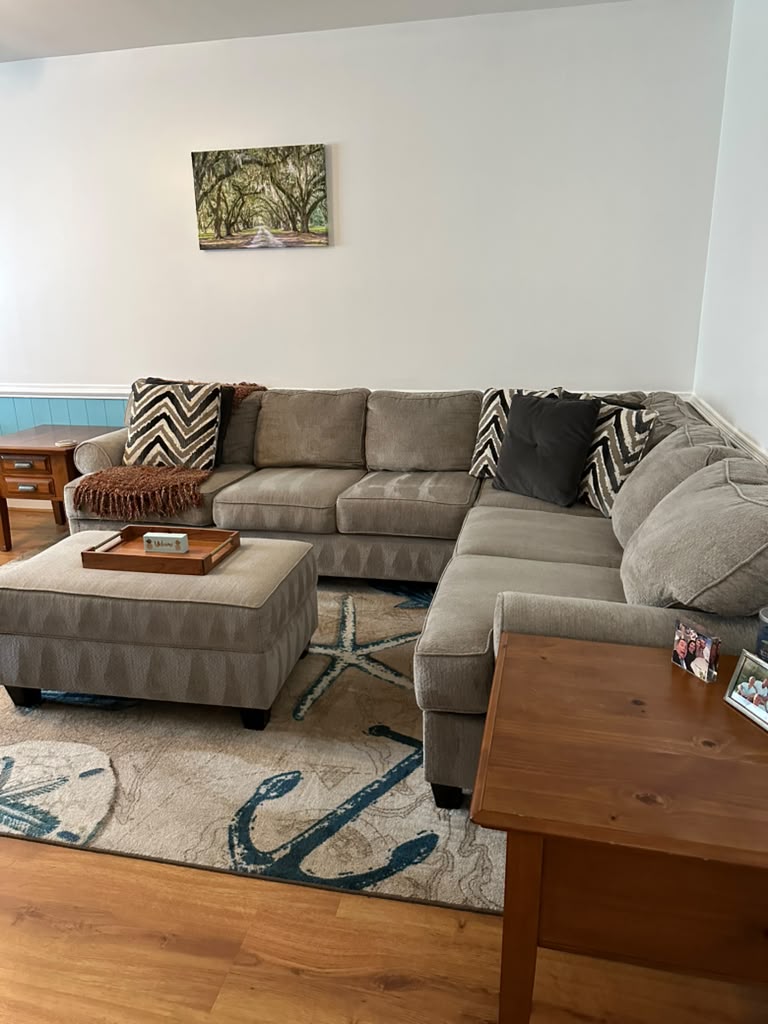 Coastal-themed sectional and area rug after a living room cleaning