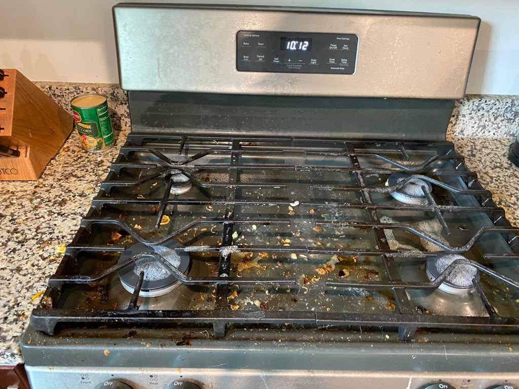 Stovetop caked in grime before a recurring cleaning visit in Richmond, VA